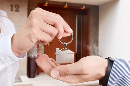 A landlord hands keys to tenant.