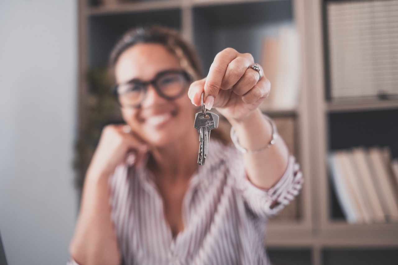 woman holding apartment key up