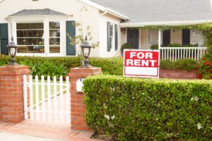 single family home with a "For Rent" sign outside