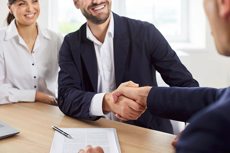 Couple shaking hands with a professional