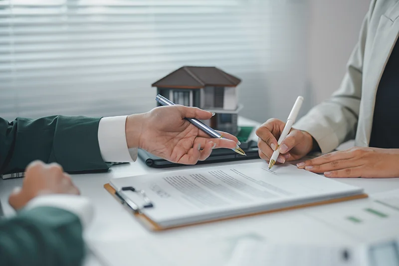 Hands holding pen and signing a paper