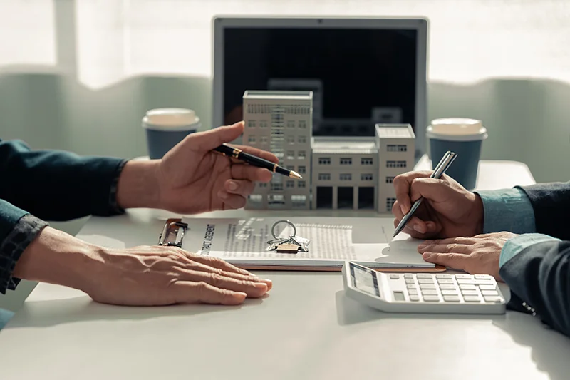 two people with pen signing over a paperwork