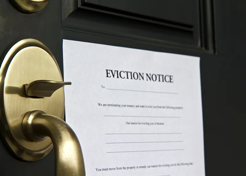 Eviction notice posted on a door for a tenant.