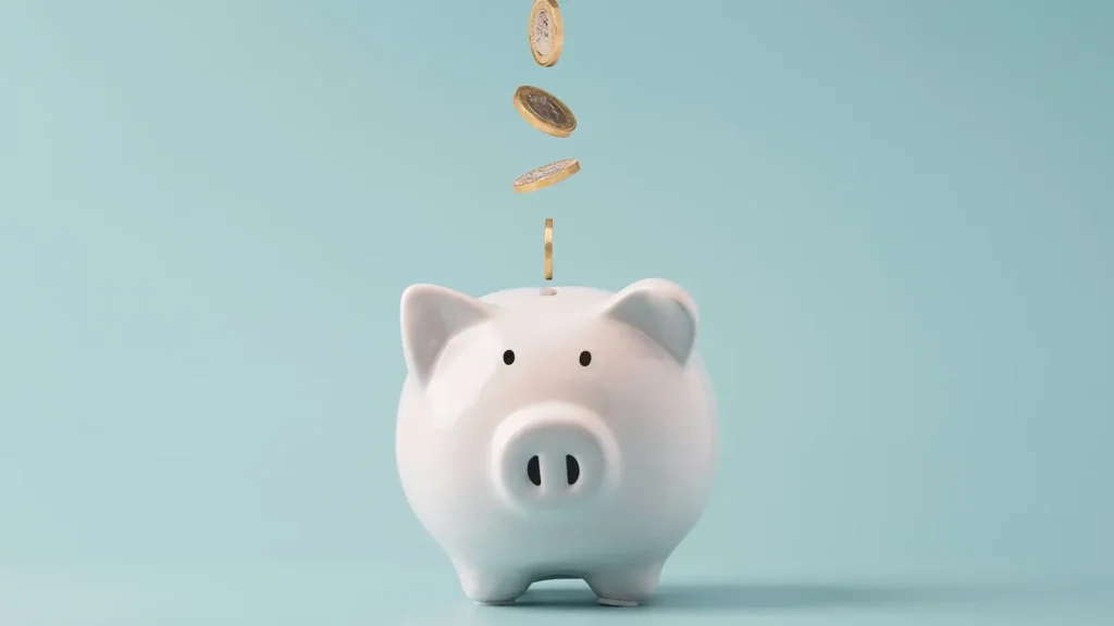 Coins dropping into a piggy bank.