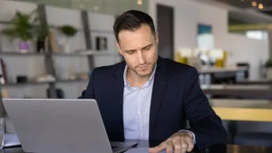 Landlord going over paperwork at a laptop.