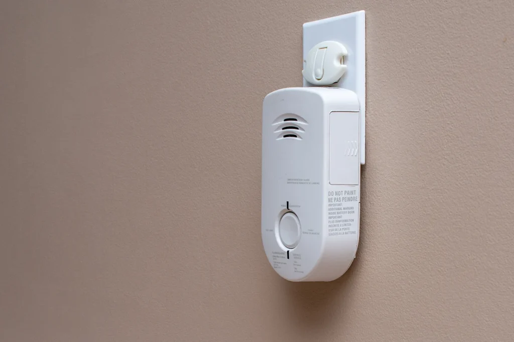 A carbon monoxide detector plugged into an outlet.