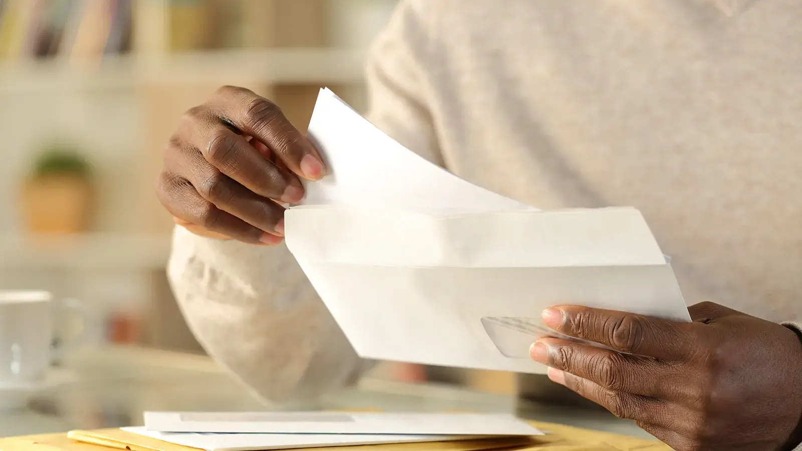 Letters being opened by someone at a desk.