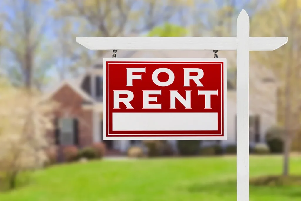 Red "for rent" sign hanging from a white post.