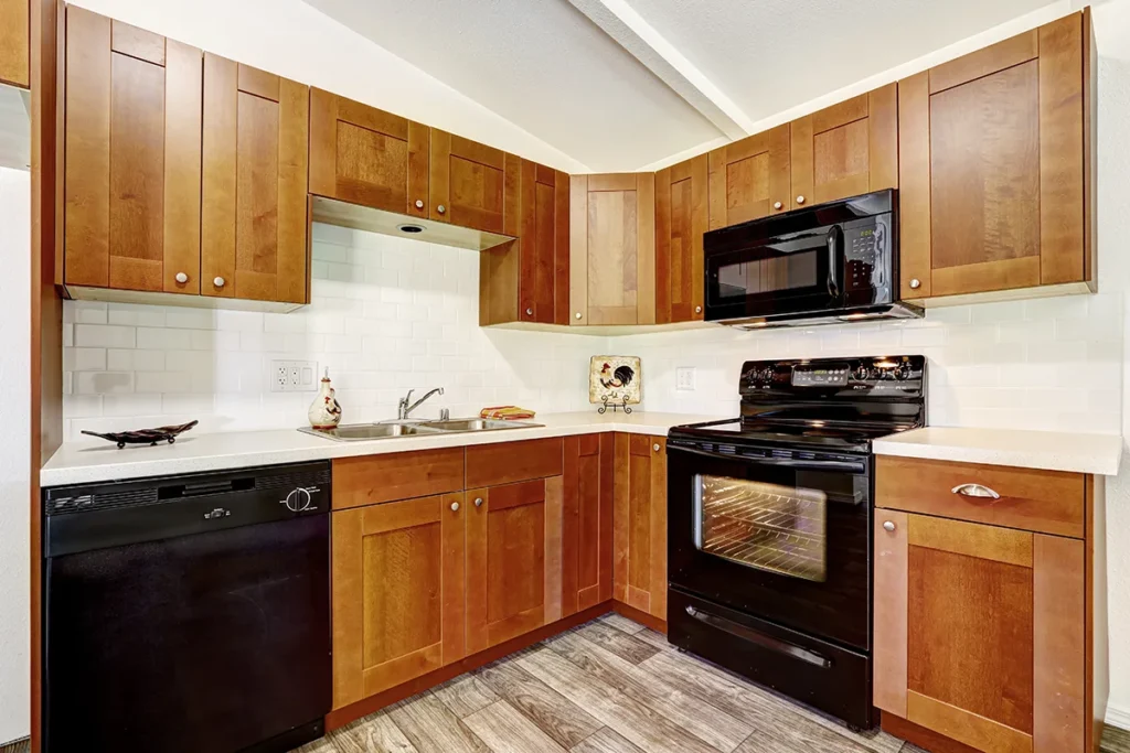 Kitchen with brown cabinets and black appliances.