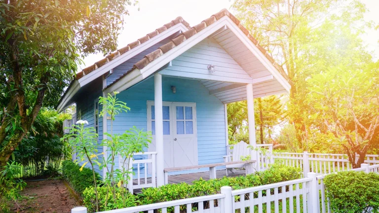 accessory dwelling unit with lush yard and white fence