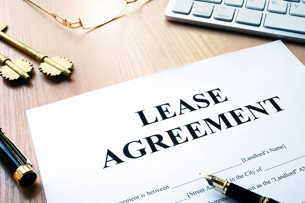 A rental lease agreement on a desk with pens and keys
